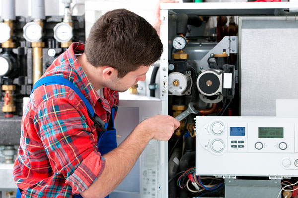 HVAC technician inspecting and repairing boiler controls in Spanish Fork