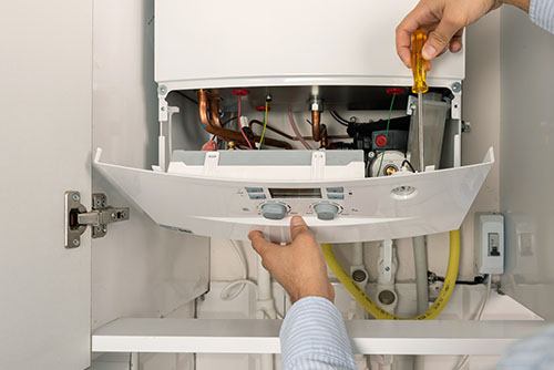 HVAC technician repairing an indoor boiler in Spanish Fork
