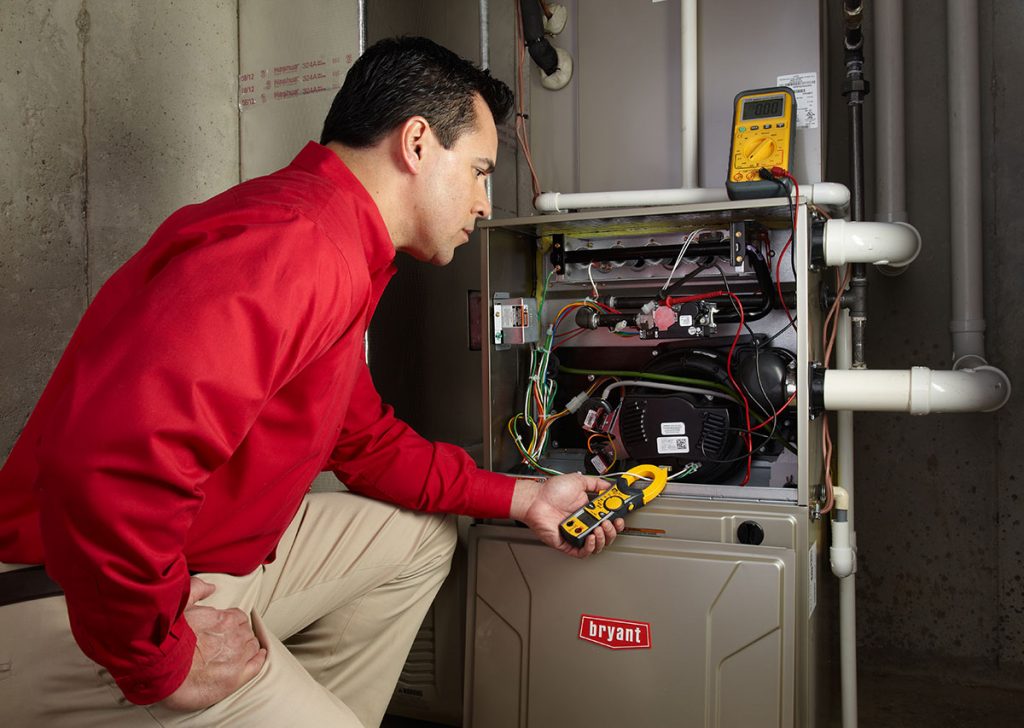 HVAC technician repairing an indoor furnace in Spanish Fork