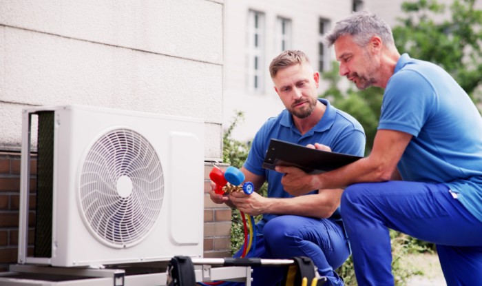 HVAC technicians installing an outdoor air conditioning unit in Spanish Fork