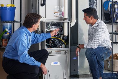 65df8c11f3e4c468cbd351a5_furnace repair vs replacement – Copy HVAC technician explaining furnace repair and maintenance to a homeowner in Spanish Fork, UT
