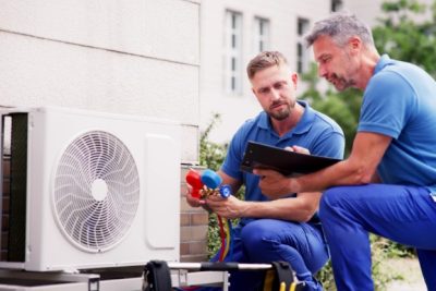 ac-installation-in-claremont-ca HVAC technicians reviewing an outdoor air conditioning unit in Spanish Fork, UT