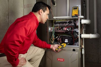 furnace repair Heating and air conditioning technician servicing an indoor furnace in Spanish Fork, UT
